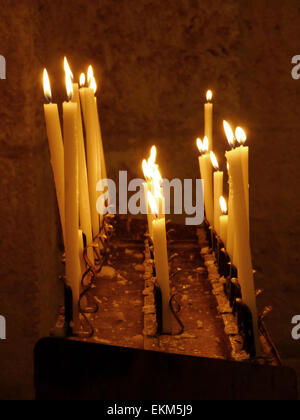 A candle holder in a church with lighted candles Stock Photo