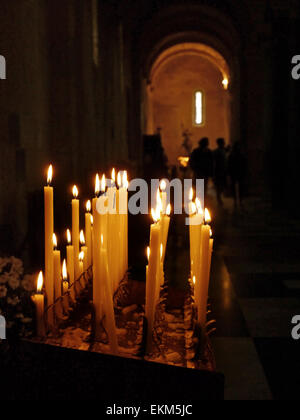 A candle holder in a church with lighted candles Stock Photo