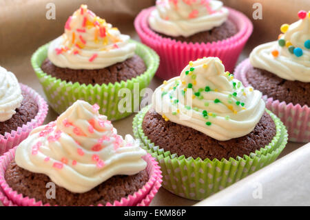 Fancy chocolate cupcakes with vanilla cream and colorful toppings and decoration Stock Photo