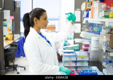Closeup portrait, young scientist in white lab coat doing experiments in lab, academic sector. Stock Photo