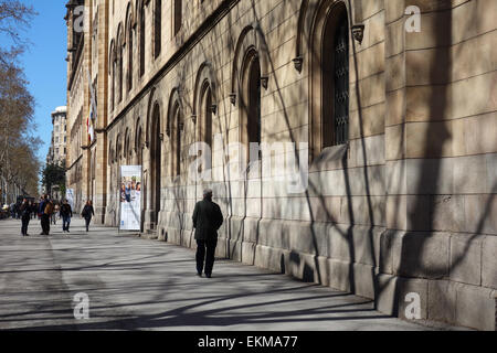 Man walking along street past University of Barcelona, Plaza Universidad, Barcelona, Catalonia, Spain Stock Photo