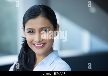 Closeup portrait, young professional, beautiful confident woman in blue shirt, friendly personality, smiling isolated indoors of Stock Photo