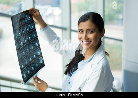 Closeup portrait of intellectual woman healthcare personnel with white labcoat, looking at full body x-ray radiographic image Stock Photo