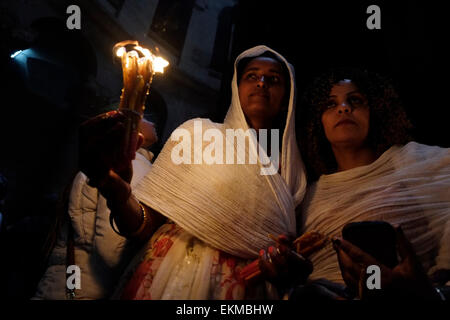 Ethiopian Orthodox Christians light candles and pray during the Holy Fire ceremony at Deir El-Sultan monastery located on roof of the Church of Holy Sepulchre in the Old City East Jerusalem Israel. Ethiopian Christians commemorate events around the crucifixion of Jesus Christ, leading up to his resurrection on Easter which in the Amharic language, is referred to as Fasika, originated from the Greek word Pascha. Stock Photo
