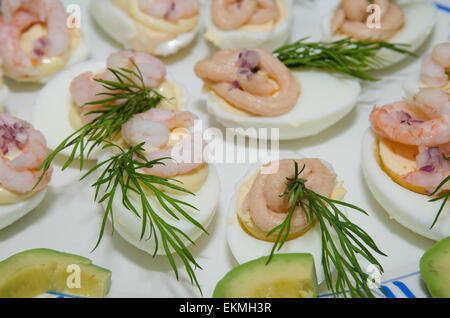 Egg halves decorated with prawns, caviar, dill, red onion and mayonnaise Stock Photo