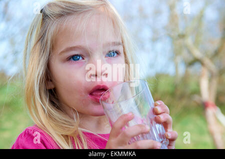 Close up of Child blond girl drinking lemonade outside summer time Stock Photo