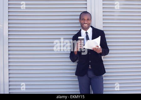 stylish black man documents handling outdoors Stock Photo