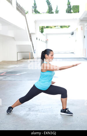 Beautiful hispanic sport woman demonstrating tai chi stance  'parting horse mane', outdoor. Concept of healthy lifestyle. Stock Photo