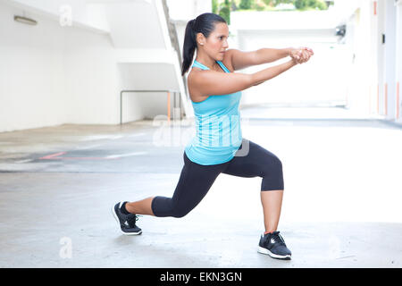 Beautiful hispanic sport woman demonstrating tai chi stance with pretend sword, outdoor. Concept of healthy lifestyle. Stock Photo