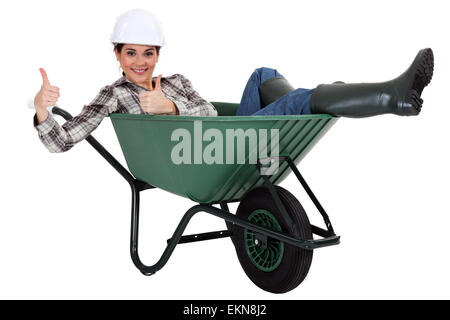 female bricklayer thumbs up in wheelbarrow Stock Photo