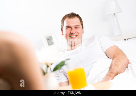 woman brought her boyfriend breakfast in bed Stock Photo