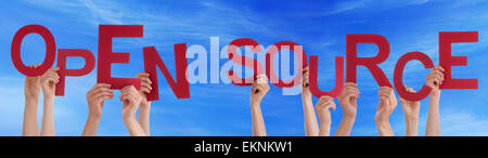 Many Caucasian People And Hands Holding Red Letters Or Characters Building The English Word Open Source On Blue Sky Stock Photo