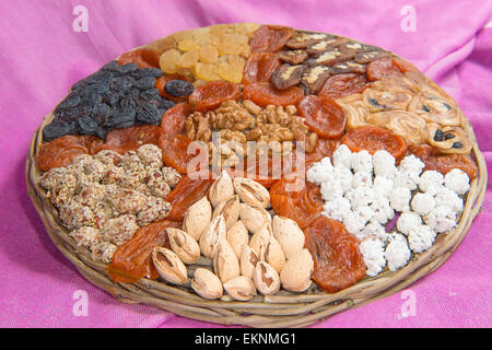 Assorted nuts and dried fruits in wicker plate Stock Photo