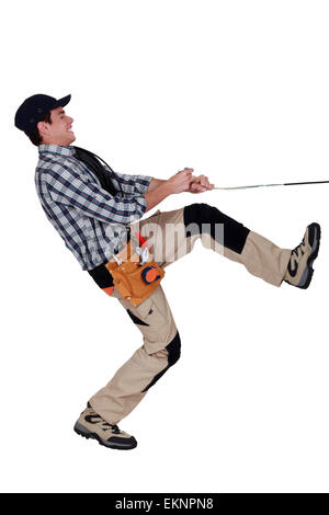 Handyman pulling a rope Stock Photo