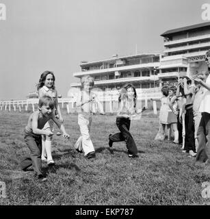 Children race across the finish line of the egg and spoon race on the Downs at Epsom where coaches of the children had a holiday away from Peckham. The day out was organised by the Peckham Settlement. Surrey, 16th August 1973. Stock Photo