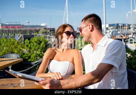 smiling couple with menu at cafe Stock Photo