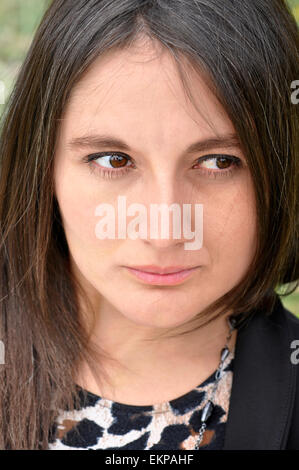 Young woman sadly looking with expression of melancholy eyes. Stock Photo