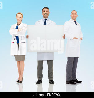 group of smiling doctors holding white blank board Stock Photo