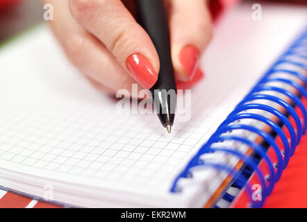 Female hand writing in blank notebook, close up Stock Photo