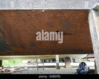 Rust holes in the hull of an old steel hulled boat Stock Photo