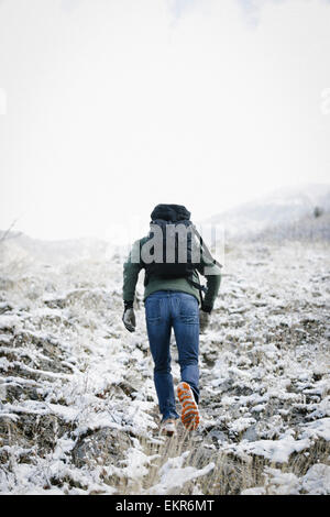 A man hiking through the mountains carrying a rucksack. Stock Photo