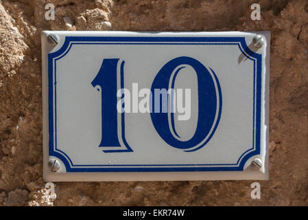 Blue and white number 10 ceramic plaque on a house wall Stock Photo