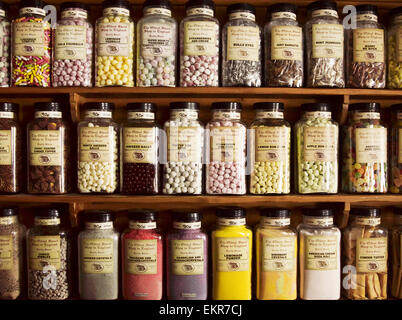 Traditional sweets displayed in tall glass jars on the shelves of a sweet shop. Stock Photo