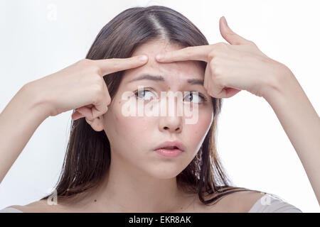 Chinese woman squeezing a spot on her forehead Stock Photo