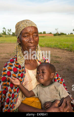In mid January 2015, a three day period of excessive rain brought unprecedneted floods to the small poor African country of Malawi. It displaced nearly quarter of a million people, devastated 64,000 hectares of alnd, and killed several hundred people. This shot shows a displaced grand mother and child in Chiteskesa refugee camp, near Mulanje. Stock Photo