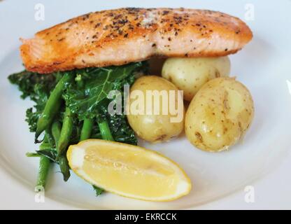 salmon fillet Balanced meal Grilled pan seared Atlantic with new potatoes, seasonal greens and a lemon wedge gluten free Stock Photo