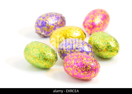 Close-up of several chocolate Easter eggs in colorful wrappings isolated on white background Stock Photo
