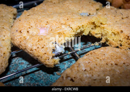 Easter cookies with mini chocolate eggs inside on a wire tray straight after baking. Stock Photo