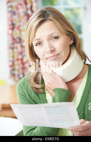 Woman Reading Letter After Receiving Neck Injury Stock Photo