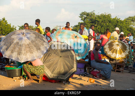 Women sheltering from the sun under umbrelaas at an African market on the roadside in Ckiwawa, Malawi, Africa. Stock Photo