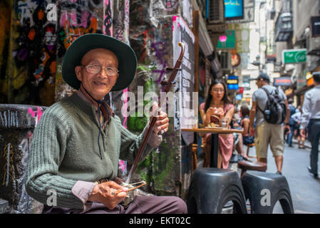 A busker performs with a traditional Erhu Chinese fiddle in Melbourne's Centre Place café strip Stock Photo