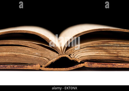 ancient book shot on black background. The book is in bad condition. Stock Photo