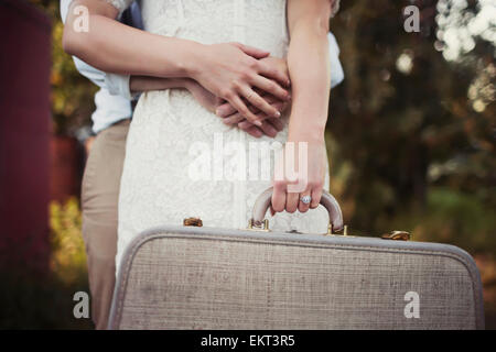 A couple holding a vintage suitcase; Edmonton, Alberta, Canada Stock Photo