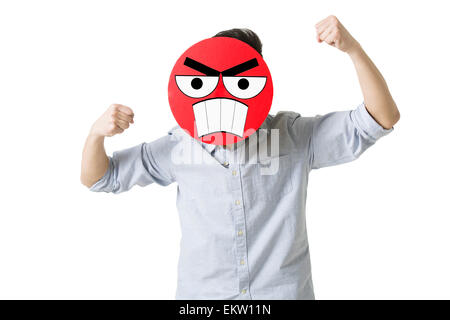 Young man with a angry emoticon face in front of his face Stock Photo