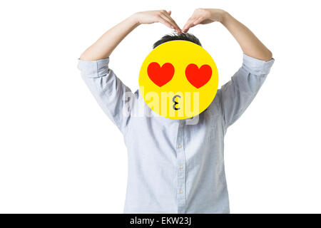 Young man with a romantic emoticon face in front of his face Stock Photo