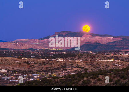 The March 5, 2015 mini-moon rises over the Santa Rita Copper Mine and cliff formation known locally as the Kneeling Nun, east of Stock Photo