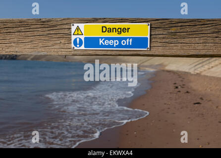 Danger keep off sign on a groyn at a beach in Dawlish Warren Devon England UK Stock Photo