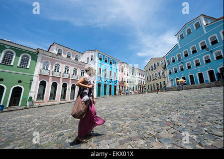 SALVADOR, BRAZIL - MARCH 12, 2015: Pedestrian passes in front of colorful colonial architecture in Pelourinho. Stock Photo