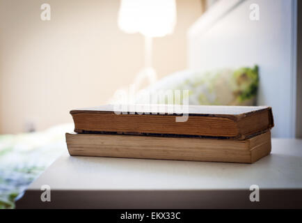 bedroom with books on nightstand Stock Photo