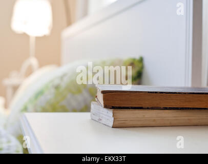 bedroom with books on nightstand Stock Photo