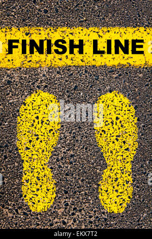 Finish Line message. Conceptual image with yellow paint footsteps on the road in front of horizontal line over asphalt Stock Photo