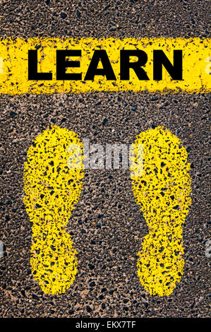 Learn message. Conceptual image with yellow paint footsteps on the road in front of horizontal line over asphalt Stock Photo