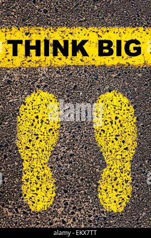 Think Big message. Conceptual image with yellow paint footsteps on the road in front of horizontal line over asphalt Stock Photo