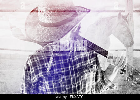 Bearded Cowboy Farmer with Acoustic Blues Guitar and Straw Hat on Western American Horse Ranch, Double Exposure Image. Stock Photo