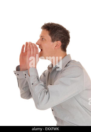 A young man holding his hands on his mouths and shouting with his mouths open, isolated for white background. Stock Photo