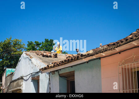 Cuba Trinidad workers worker workmen repairing retiling tiling roof Stock Photo
